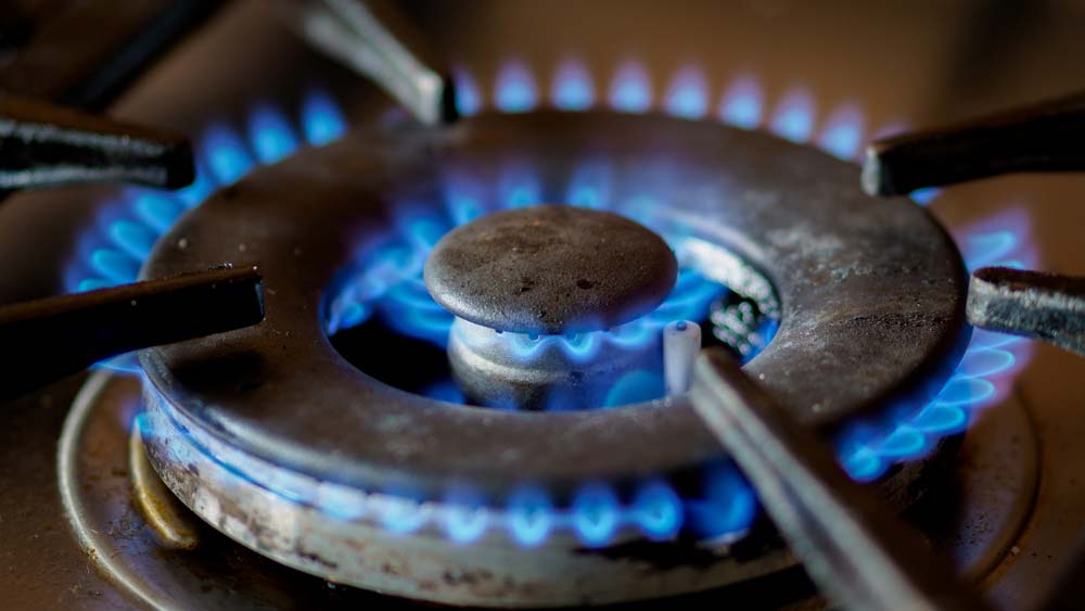 a close up of a gas stove with blue flames.